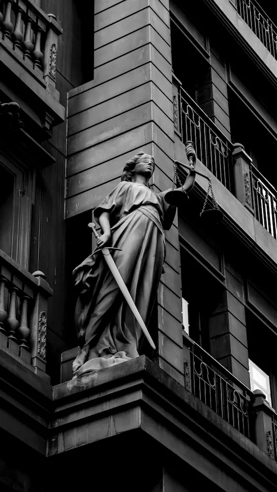 Lady Justice statue holding scales and sword on a courthouse facade