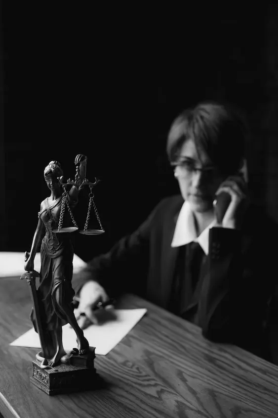 Lady Justice statuette on a desk with a Campbelltown AVO lawyer on the phone