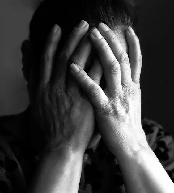 Male criminal with hands covering face